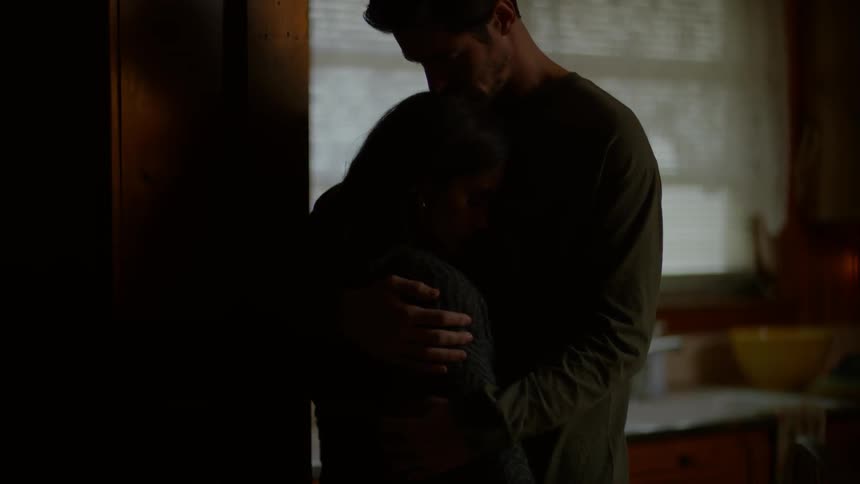 A man is hugging a woman in the kitchen