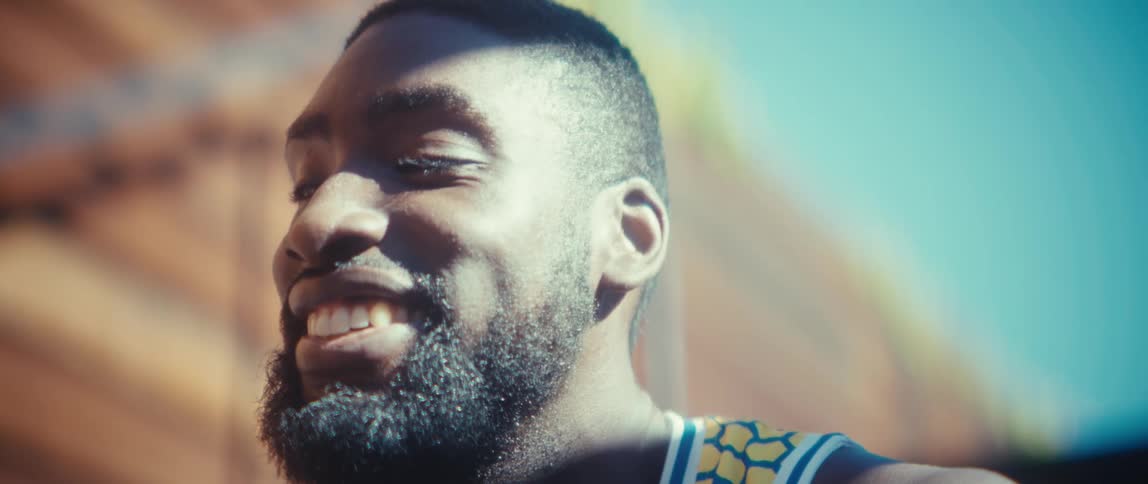 Man smiles as he holds his phone