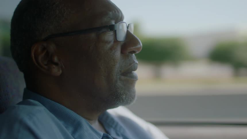 A man drives a car down the road