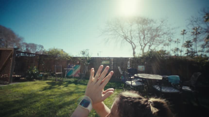 A woman stands in a sundrenched backyard raising her arms toward the sky in a fluid yoga stretchshe eventually brings her hands together in a prayer position closing her eyes to find a moment of quiet focus