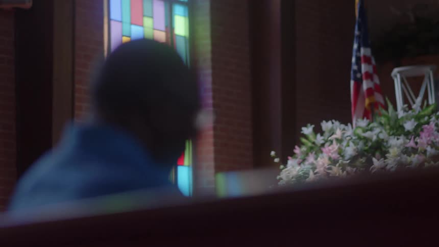 A man sits in a church pew
