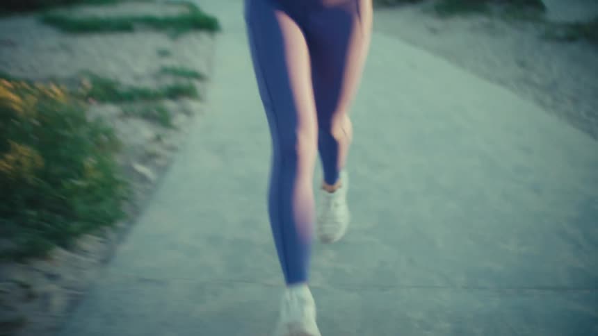 Woman jogging on a sidewalk at the beach