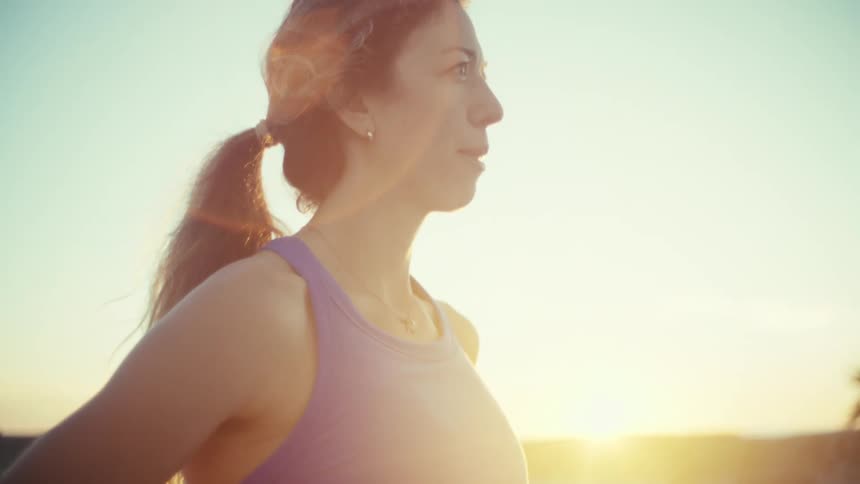 A woman running outdoors on a sunny day