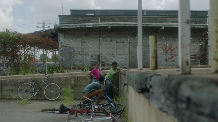 Kid helps other kids get up onto concrete platform