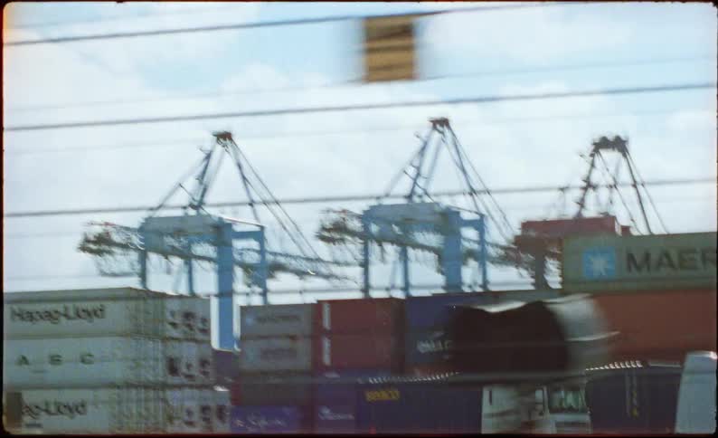 Storage tanks and loading docks stand near a highway during the daytime
