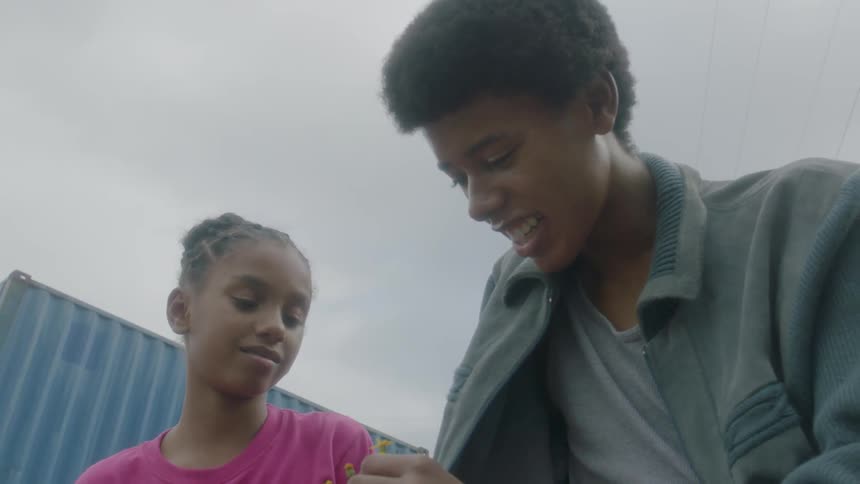 A young girl hands flowers to a boy