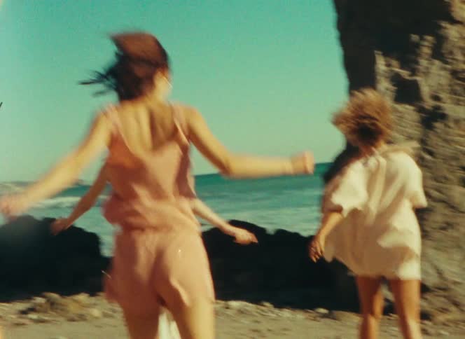 Three women running on a beach