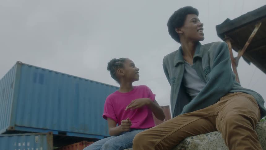 Two people talk sitting on a concrete ledge