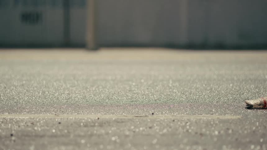 Cigarette butt on asphalt with blurred vehicle in the background