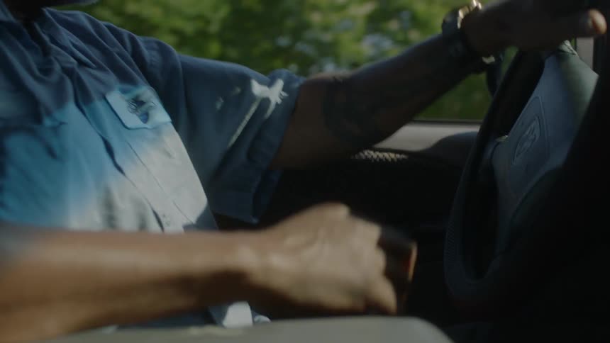 A man is driving a car turning the wheel