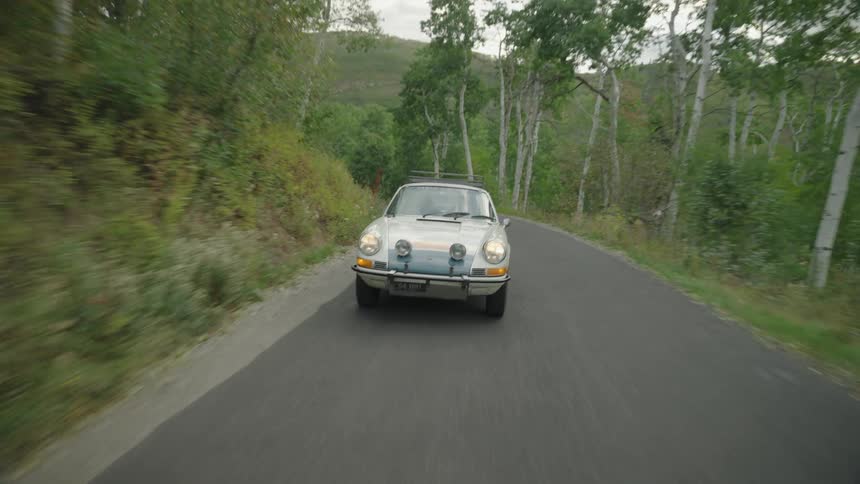 A view of a car driving outdoors on a sunny day