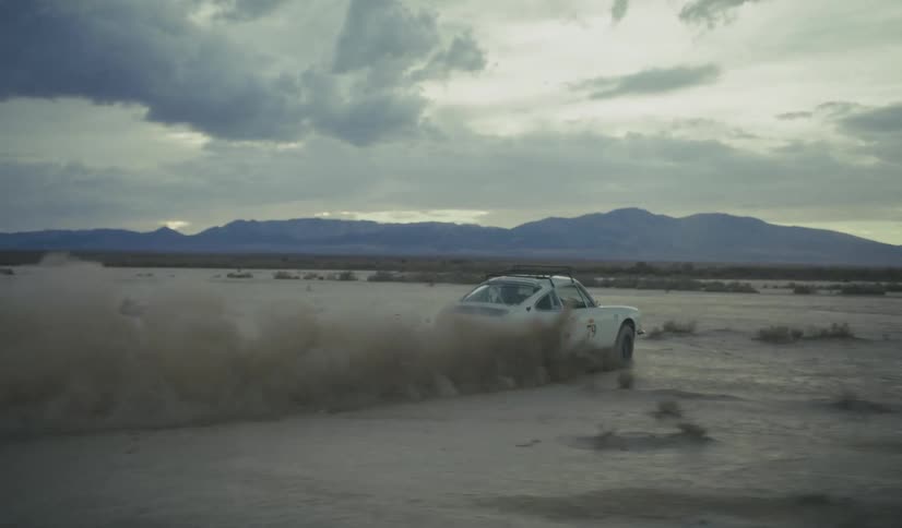 A man in a vehicle is moving across the desert