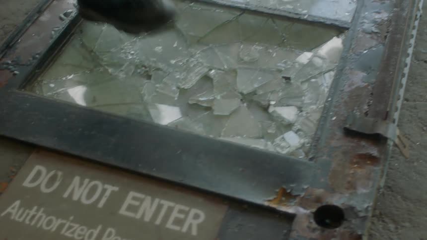 People step over shattered glass on the ground