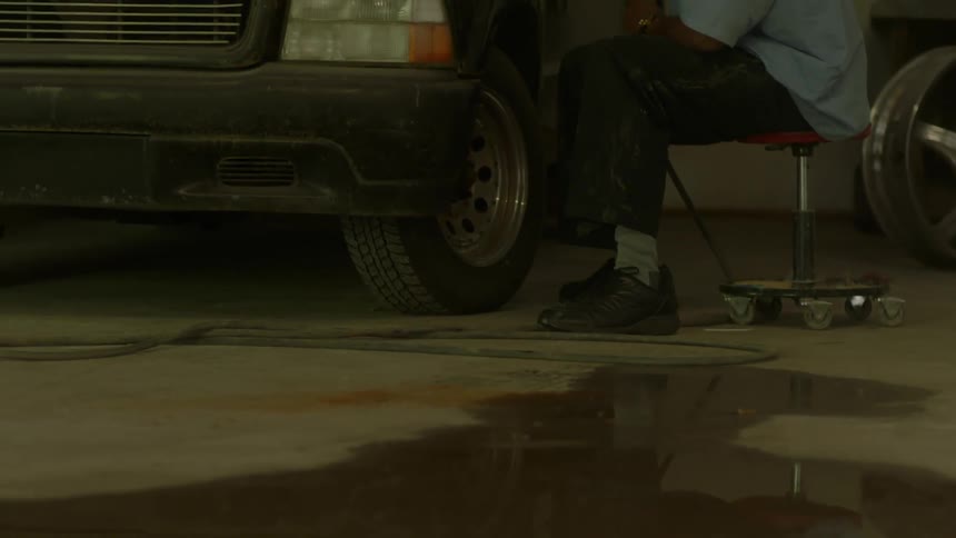 A man is sitting near a car