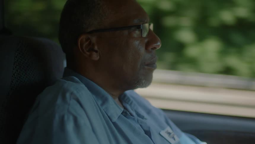 A man is sitting in a car driving