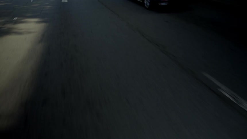 The street passes by showing shadows and arrows