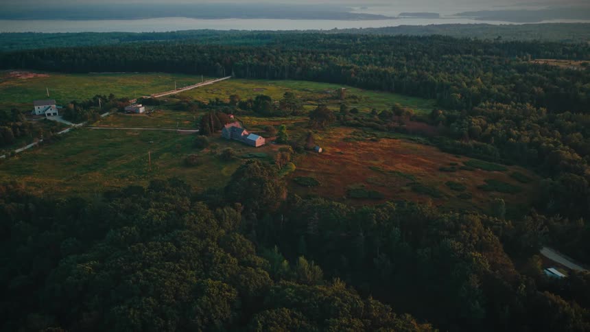 Rural area with a house straight road open fields and forest in the background near a body of water