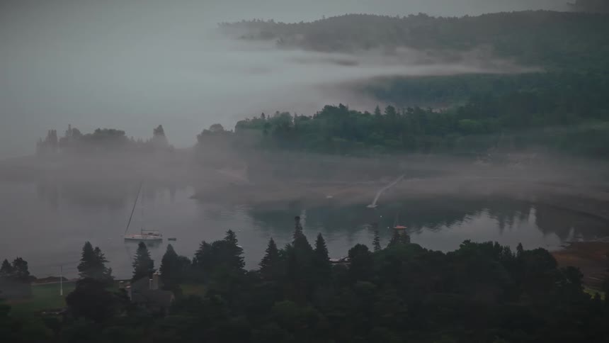 An aerial view of a lake with clouds around it