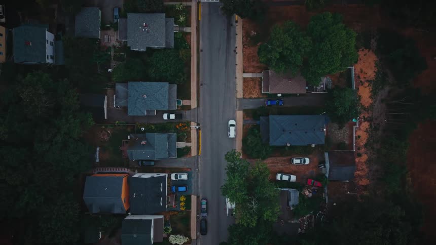 Vehicles are parked around houses in a neighborhood