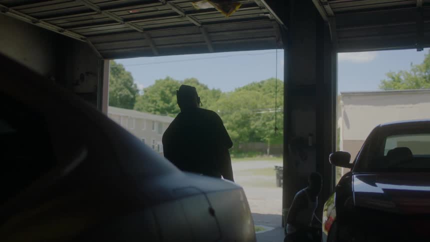 Men stand in a car garage