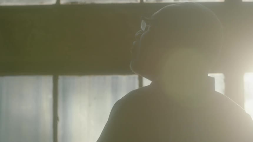 Man looking out a window on a sunny day