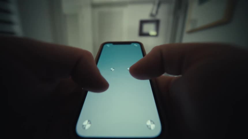 Human male hands tapping on a replaceable screen on a smartphone while the person is walking through the corridors of a house indoors during day time