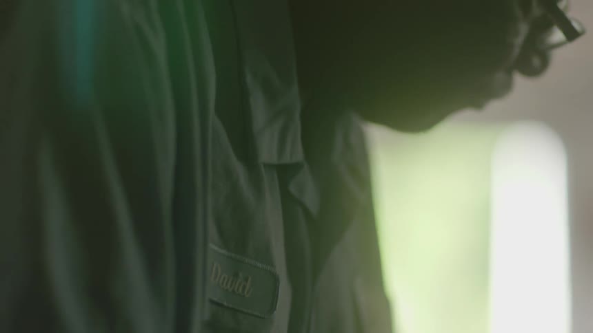 A man in a work shirt works on something