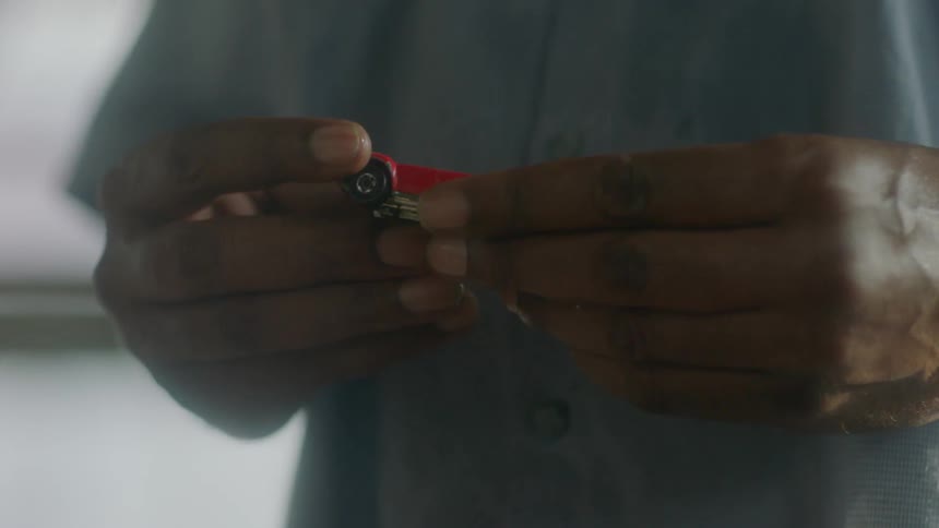 A man holds a small toy car