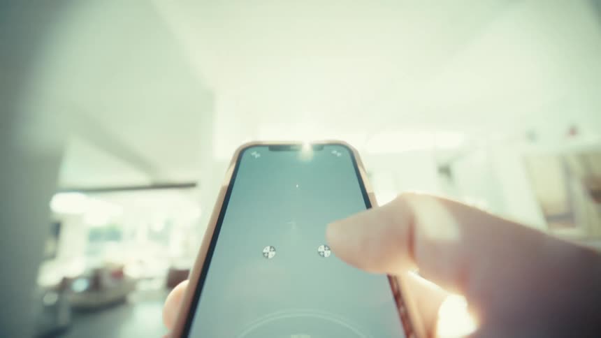 A close view of a person using a thumb to scroll on a smartphone screen inside a bright room with soft light and a blurred background
