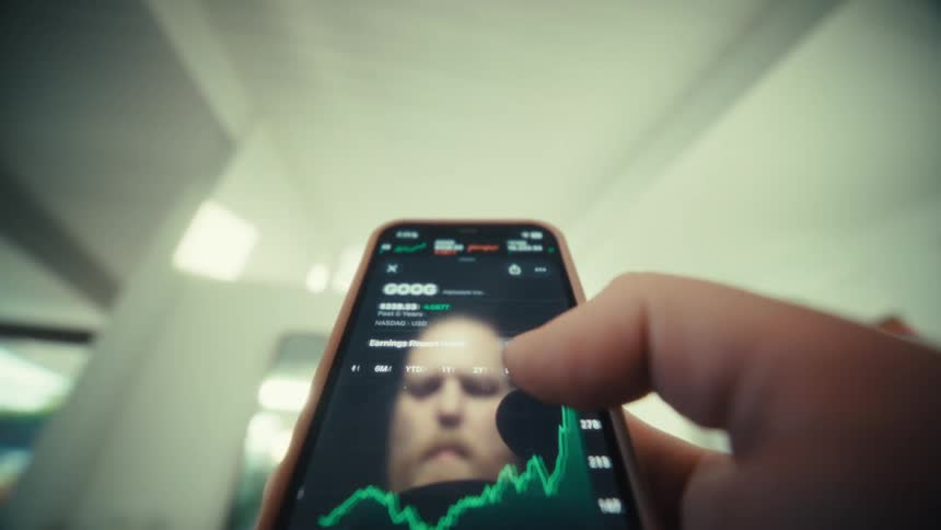 Hand touching a smartphone screen displaying a rising financial chart