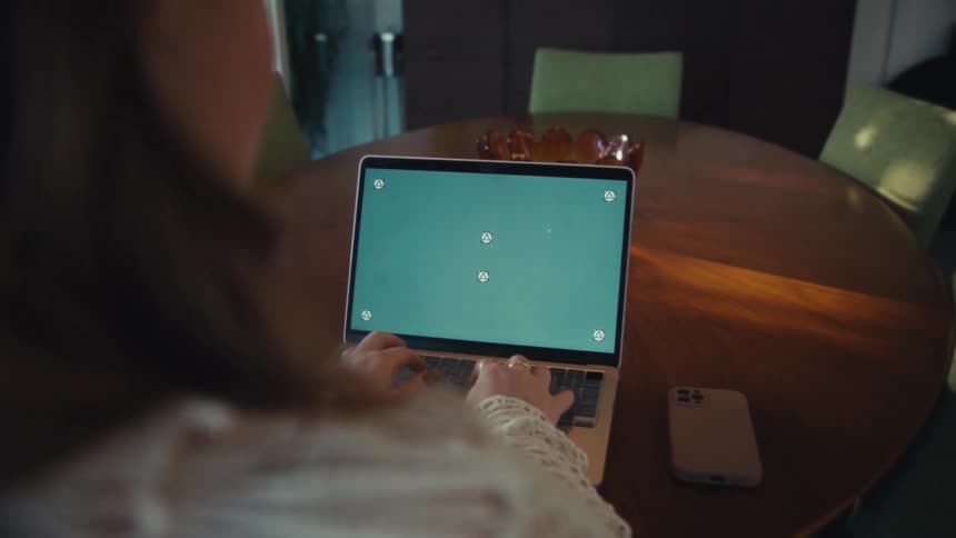 A woman typing on the keyboard of a laptop on a table