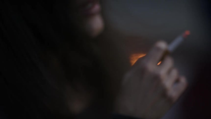 A woman smokes a cigarette