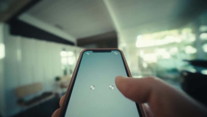 A person walking inside an office space at midday scrolling on his smartphone