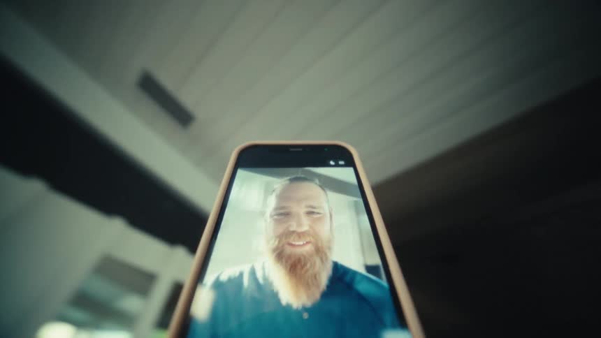 The man is recording himself with a cell phone