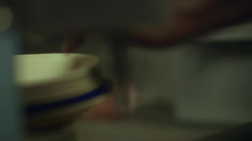 Person rinsing dishes in industrial sink