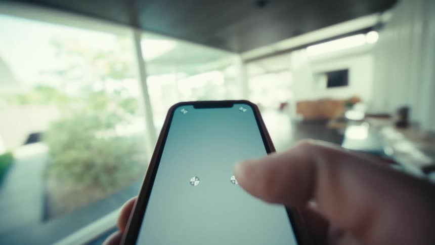 The person walks into the home while using a cell phone