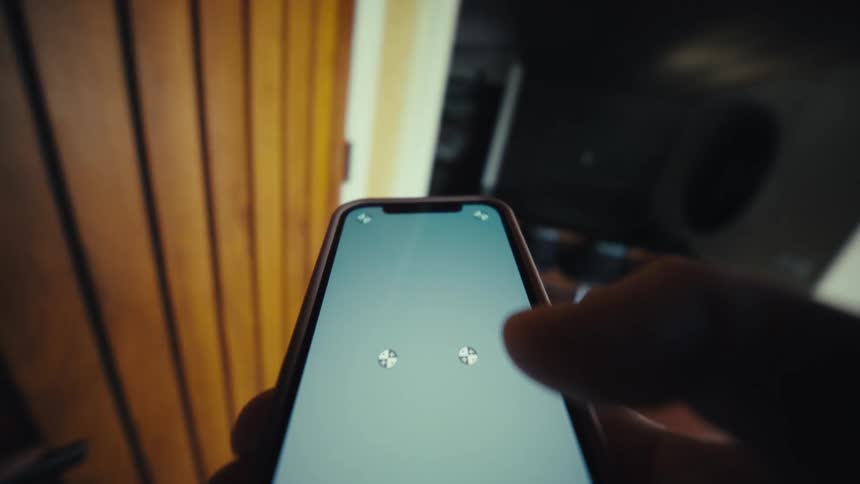 A person holds their phone as they pick up the keys and walk through an office