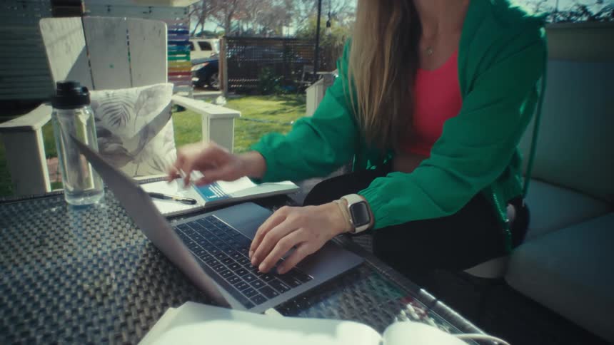 A woman is typing on a laptop then closes the top