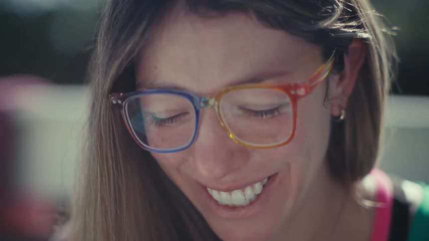 A woman putting on glasses