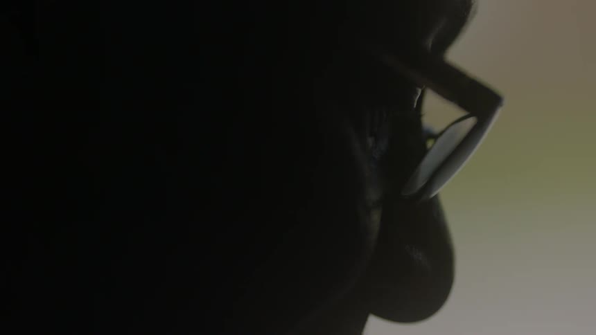 Close-up of a spectacled man studying something