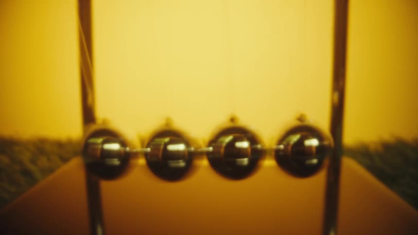 A view of metal balls swinging in a newtons cradle