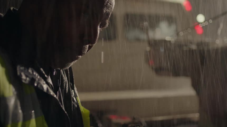 A man is working outside in the heavy rain