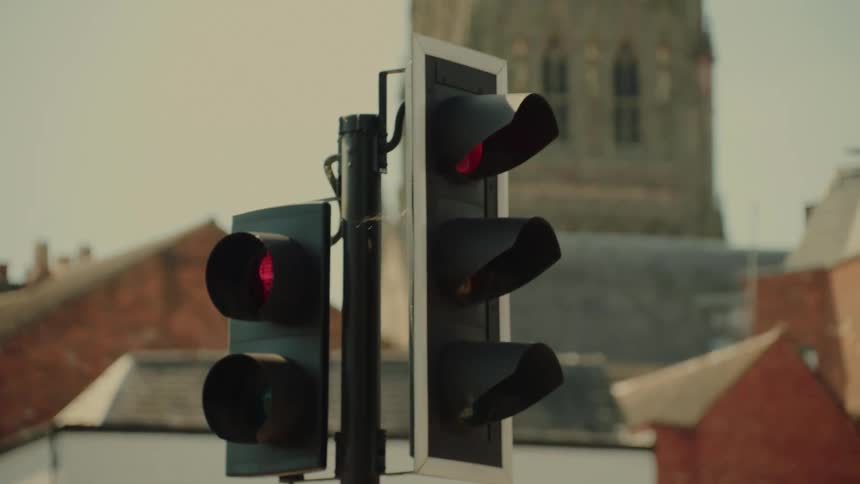 Traffic lights are next to old buildings in a city