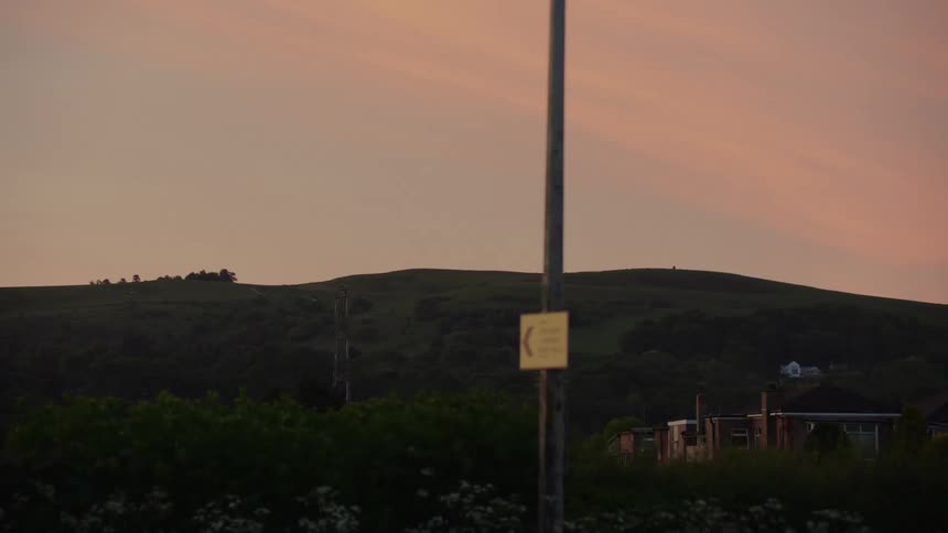 A warm sunset sky over distant rolling hills
