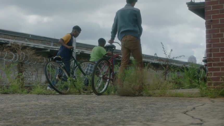 People walk their bikes on a cloudy day