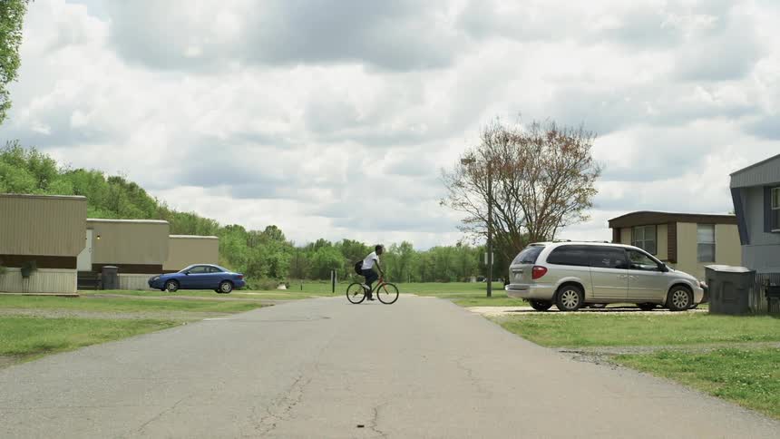 Man rides bike in a small neighborhood