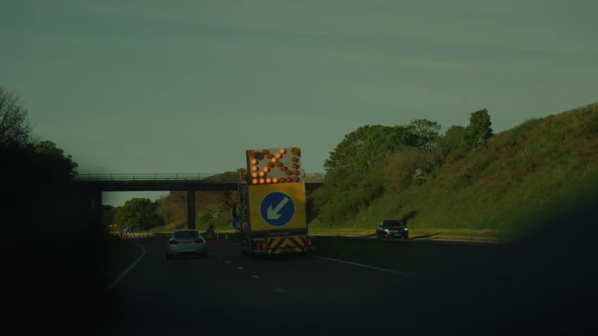 Incident protection vehicle with illuminated sign on the road at daytime