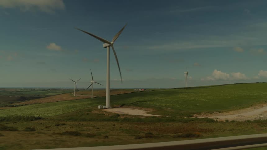 Wind turbines are moving in the wind in a large field