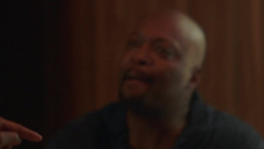 A man and woman argue while sitting at a table