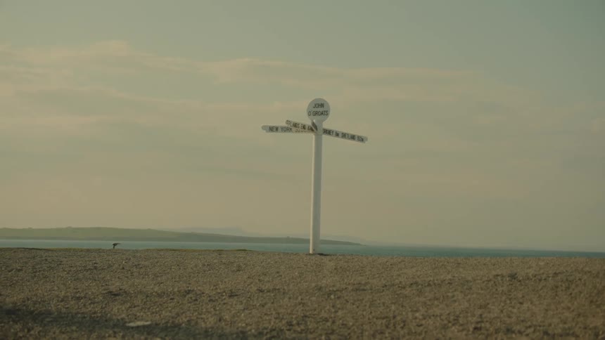 John ogroats direction signpost set by the seaside with the ocean horizon in the background